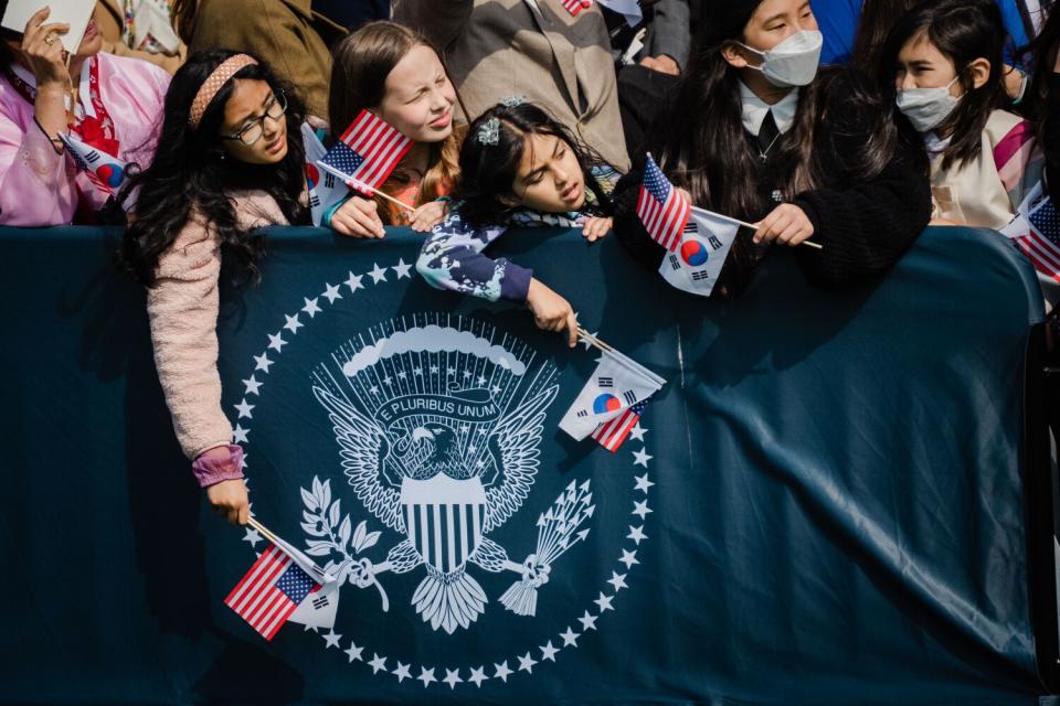 Young people hold flags at the South Lawn of the White House