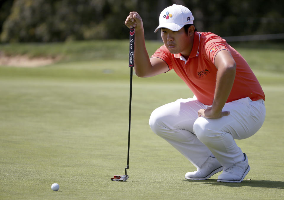 Byeong Hun An of South Korea lines up his putt on the first green during the Australian Open Golf tournament in Sydney, Thursday, Nov. 15, 2018. (AP Photo/Rick Rycroft)