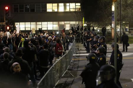 Protesters chant in front of a police line outside Berkley Police Department headquarters during a march against the New York City grand jury decision to not indict in the death of Eric Garner in Berkeley, California December 9, 2014. REUTERS/Stephen Lam