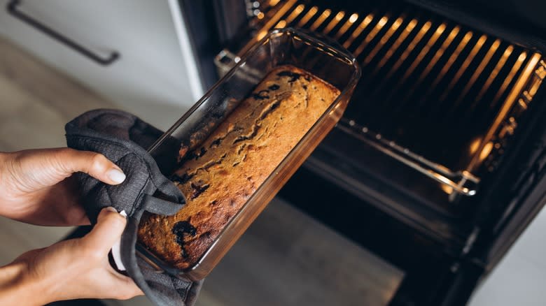 person taking banana bread out of oven