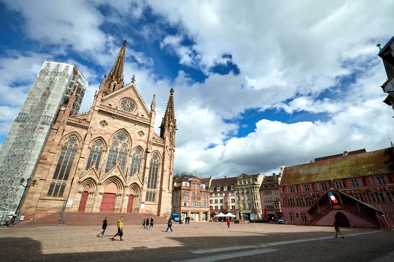 People walk in front of the Saint-Etienne church in Mulhouse