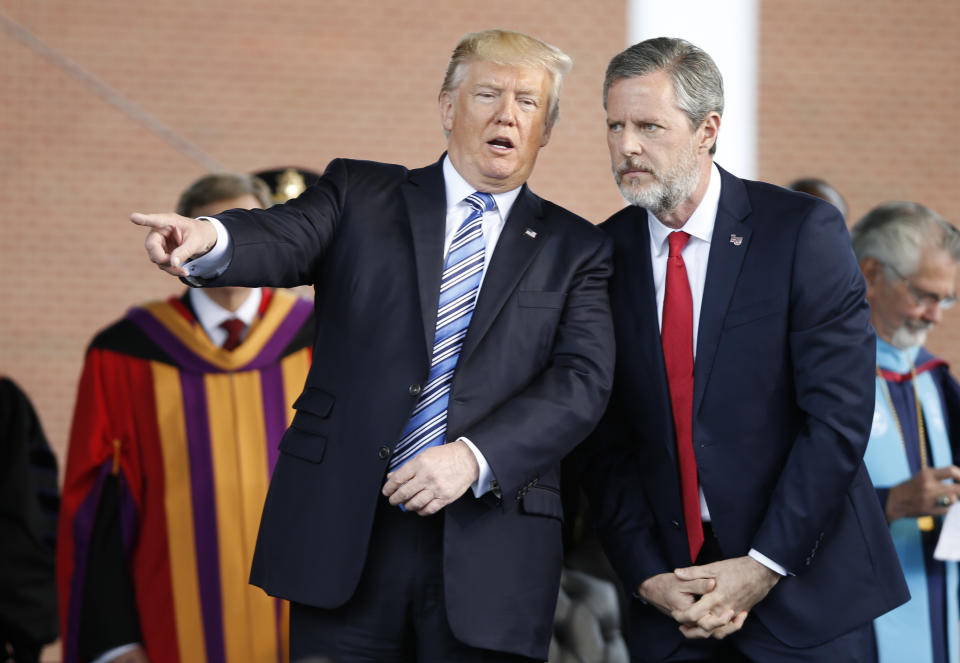 FILE - In this May 13, 2017 file photo, President Donald Trump gestures as he stands with Liberty University president, Jerry Falwell Jr., right, during commencement ceremonies at the school in Lynchburg, Va. Falwell Jr., said in an interview that he and President Donald Trump are in regular communication but described himself as “not a spiritual adviser, not a counselor. I’m just his friend.” (AP Photo/Steve Helber)