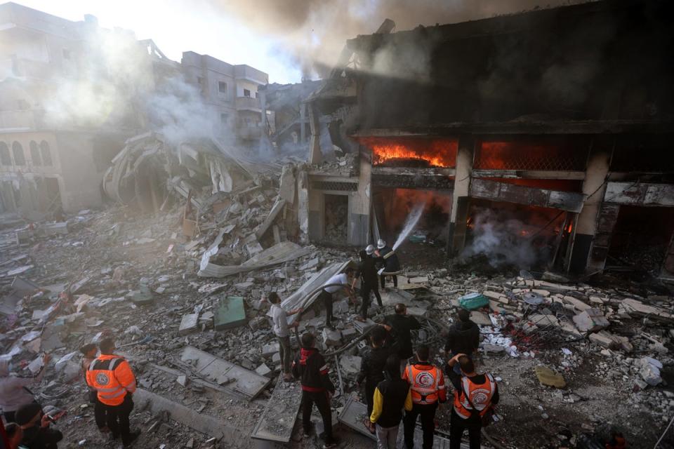 Firefights battle flames in a building hit by an Israeli strike in Khan Yunis in the southern Gaza Strip on December 9, 2023. (AFP via Getty Images)