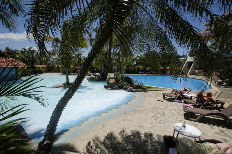 FILE PHOTO: Tourists sunbathe near a pool in a hotel, as Costa Rica tourism industry braces for coronavirus disease (COVID-19) outbreak, in Heredia