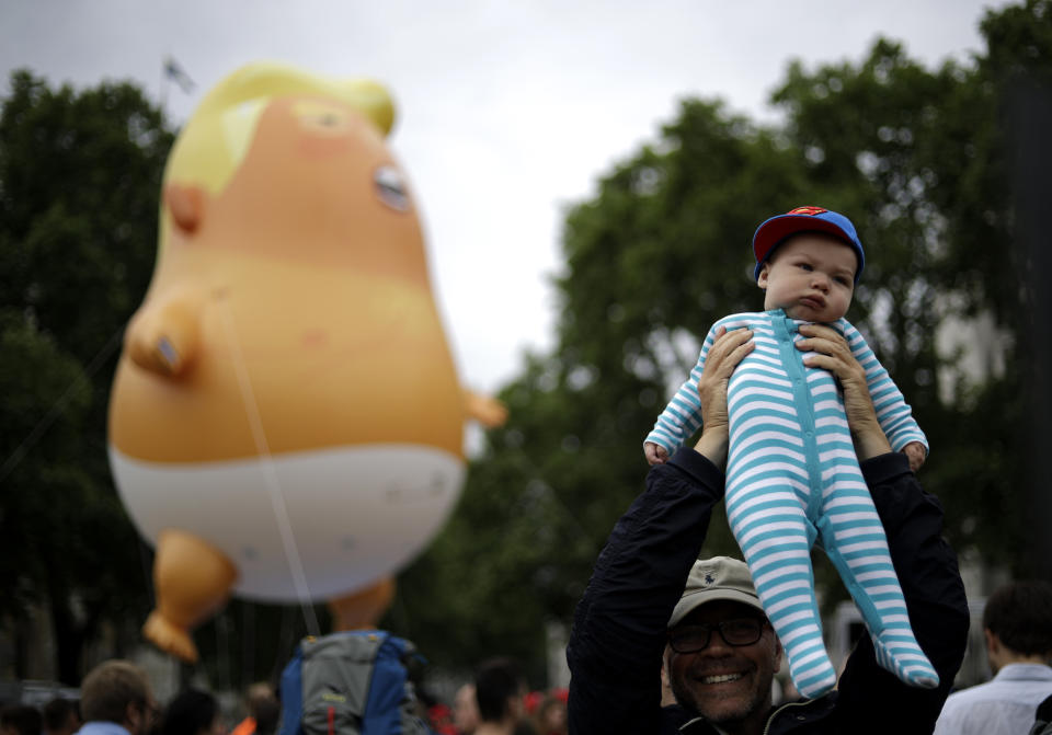 A real baby nearby the "Trump Baby" blimp in Parliament Square. (Photo: Matt Dunham/AP)