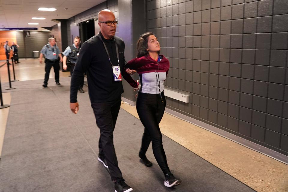 An animal cruelty activist is taken away in handcuffs after she attempted to protest during the Minnesota Timberwolves and Memphis Grizzlies Game 4 of an NBA basketball first-round playoff series April 23 in Minneapolis.