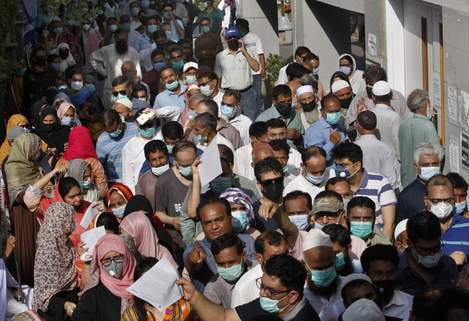 People stand in queues while they wait their turn to receive the first shot of the Sinopharm COVID-19 vaccine at a vaccination center in Karachi, Pakistan, Saturday, May 8, 2021. (AP Photo/Fareed Khan)