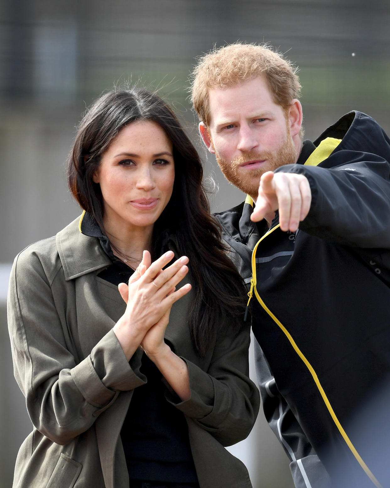 Meghan Markle, pictured with Prince Harry, wore a khaki-green coat at the University of Bath Sports Training Village to attend the U.K. team trials for the Invictus Games. (Photo: Getty Images)