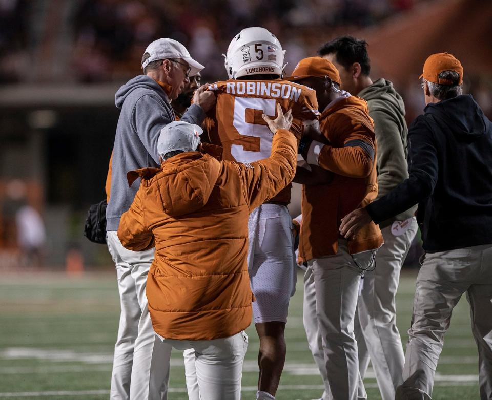 Texas running back Bijan Robinson walks off the field after getting knocked out of the Kansas game with a dislocated elbow. The Longhorns went on to lose in overtime. "I never really got, you know, injured before," he said this week. "When it happened, it was unexpected."