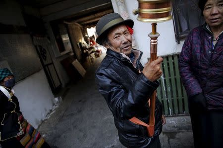 A Tibetan man spins a prayer wheel in Bakhor, in the old part of Lhasa, Tibet Autonomous Region, China in this November 16, 2015 file photo. REUTERS/Damir Sagolj/Files