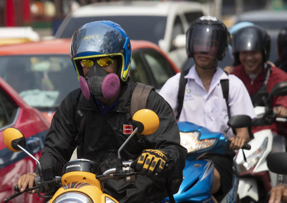 Motociclistas usan cubrebocas para protegerse de la mala calidad del aire en Bangkok, Tailandia, el lunes 20 de enero de 2020. (AP Foto/Sakchai Lalit)