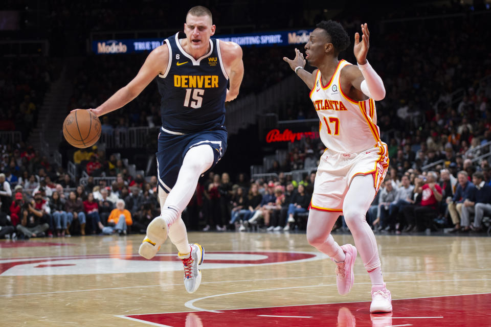 Denver Nuggets center Nikola Jokic (15) dribbles against Atlanta Hawks forward Onyeka Okongwu (17) during the second half of an NBA basketball game Friday, Dec. 2, 2022, in Atlanta. (AP Photo/Hakim Wright Sr.)