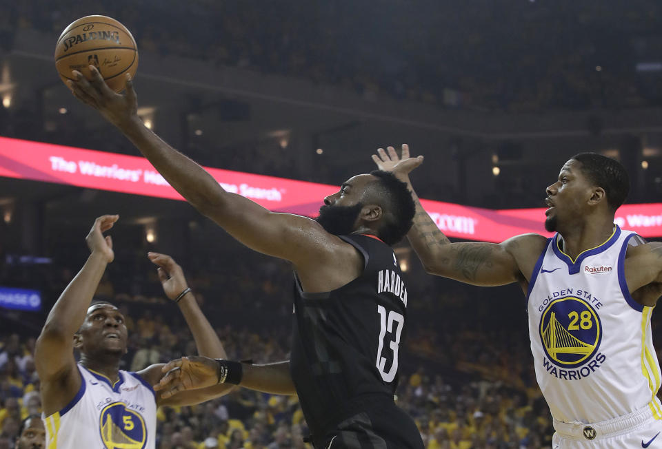 Houston Rockets guard James Harden (13) shoots between Golden State Warriors center Kevon Looney (5) and forward Alfonzo McKinnie (28) during the first half of Game 1 of a second-round NBA basketball playoff series in Oakland, Calif., Sunday, April 28, 2019. (AP Photo/Jeff Chiu)