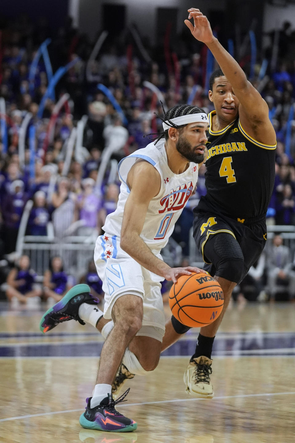 Northwestern guard Boo Buie, left, gets by Michigan guard Nimari Burnett during the first half of an NCAA college basketball game Thursday, Feb. 22, 2024, in Evanston, Ill. (AP Photo/Erin Hooley)