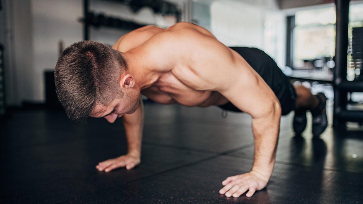  A photo of a man doing a push up. 