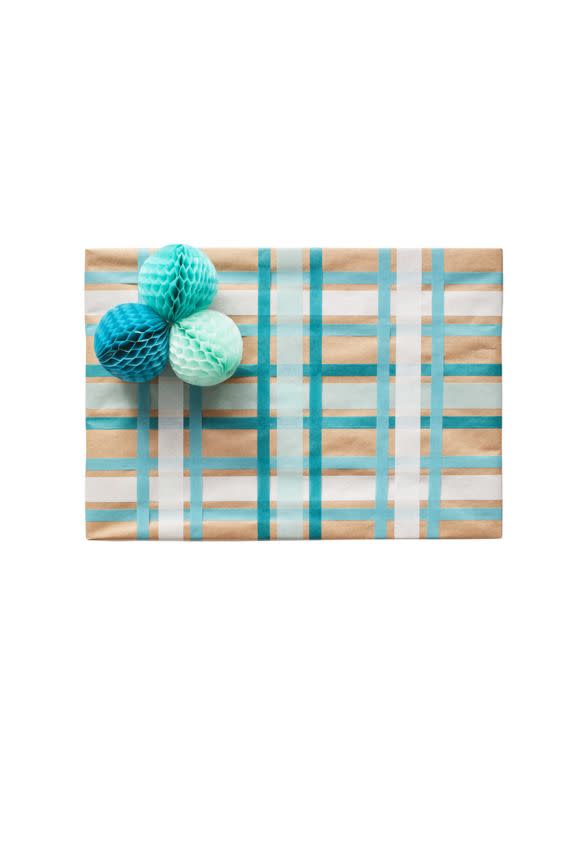 <p><strong>What you'll need:</strong></p><p>● 15mm-wide washi tape in light blue and white</p><p>● 7.5mm-wide washi tape in teal and turquoise</p><p>● String</p><p>● Paper honeycomb balls in shades of blue</p><p>● Tape</p><ol><li>Wrap your box, then place a strip of the light blue tape horizontally across the center of the box so it wraps all the way around to the back. Add a strip of white tape on either side of the blue tape, evenly spaced. </li><li>Place a strip of the teal tape on either side of the light blue tape and a strip of turquoise tape on either side of the white tape. </li><li>Repeat steps 1 and 2, but this time place the tape vertically. </li><li>Tie together three honeycomb balls and tape them to a corner of the box.<br></li></ol>