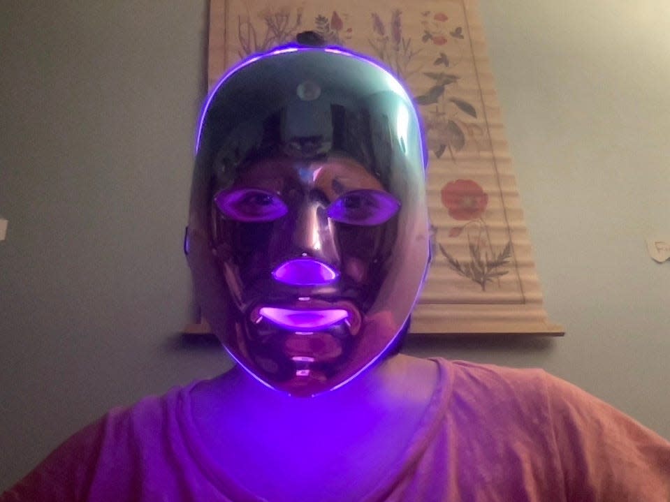 A person in a purple glowing face mask.