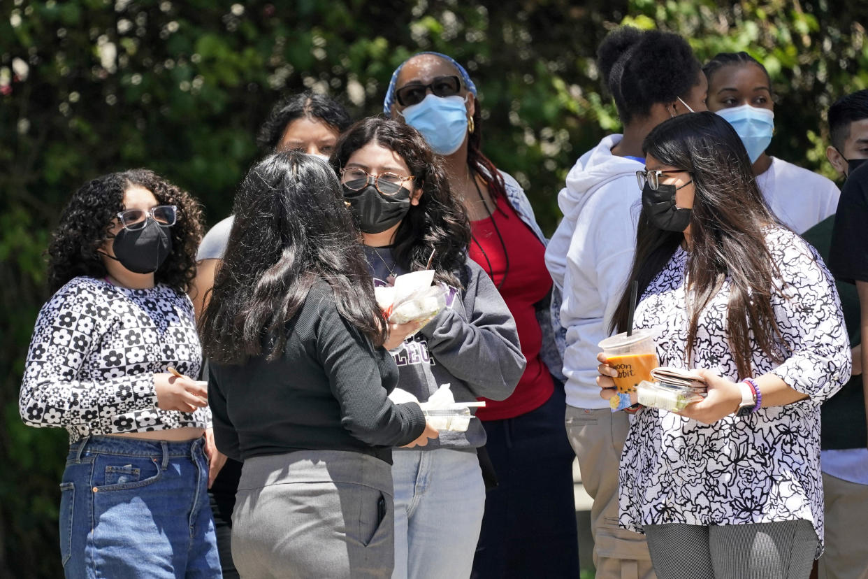 People wear a face mask while waiting at a bus stop along Hill Street Wednesday, July 13, 2022, in Los Angeles. (AP Photo/Marcio Jose Sanchez)