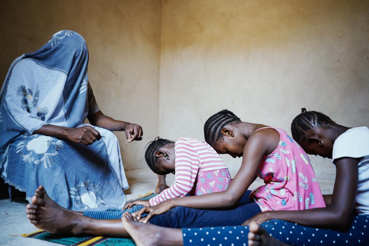 <span class="caption">Tres niñas momentos antes de sufrir mutilación genital con la cuchilla de afeitar que la cuarta persona sostiene en su mano derecha.</span> <span class="attribution"><a class="link " href="https://www.shutterstock.com/es/image-photo/totally-covered-person-holding-blade-speaking-2095148470" rel="nofollow noopener" target="_blank" data-ylk="slk:Shutterstock / Riccardo Mayer;elm:context_link;itc:0;sec:content-canvas">Shutterstock / Riccardo Mayer</a></span>