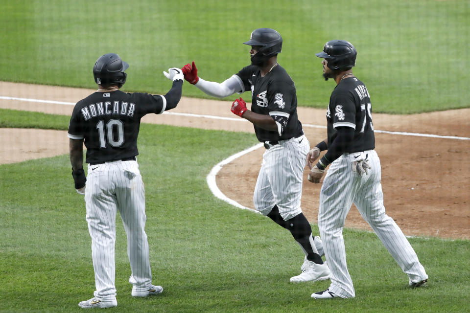 Chicago White Sox's Eloy Jimenez, center, celebrates his grand slam off Chicago Cubs starting pitcher Yu Darvish with Yoan Moncada and Jose Abreu during the first inning of a summer camp baseball game Monday, July 20, 2020, in Chicago. (AP Photo/Charles Rex Arbogast)