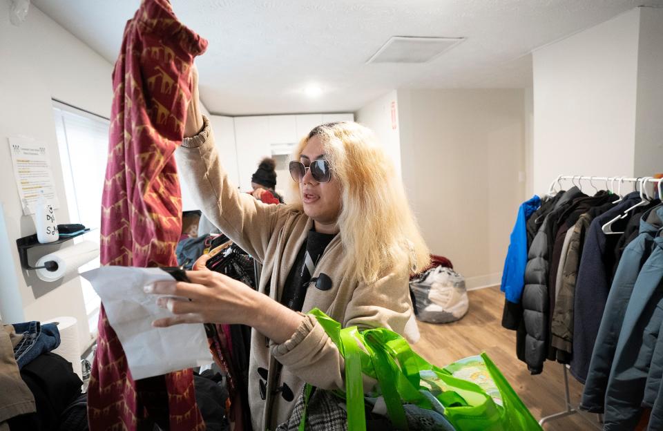 Alexey Hudson, 21, sorts through available clothing Thursday, Jan. 25, 2024, during an event held to count unhoused young adults at the Kenmore Community Center on Columbus' Northeast Side.