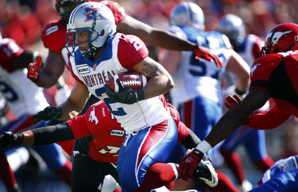 Montreal Alouettes' Brandon Whitaker, left, runs through Calgary Stampeders' defenders during first half CFL football action in Calgary, Alta., Sunday, July 1, 2012. THE CANADIAN PRESS/Jeff McIntosh