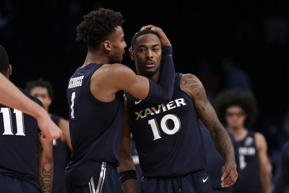 Xavier's Nate Johnson (10) and Paul Scruggs react late in the second half of the team's NCAA college basketball game against Virginia Tech in the NIT Season Tip-Off tournament Friday, Nov. 26, 2021, in New York. Xavier won 59-58. (AP Photo/Adam Hunger)