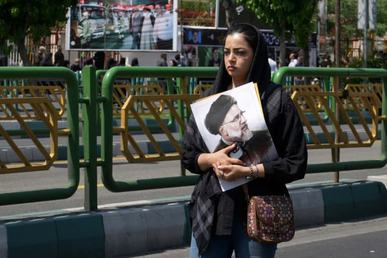 Una iraní sostiene un retrato del fallecido presidente Ebrahim Raisi durante su cortejo fúnebre, en Teherán, el 22 de mayo de 2024 (-)