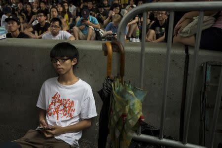 Joshua Wong, leader of the student movement, rests after delivering a speech, as protesters block the main street to the financial Central district, outside the government headquarters building in Hong Kong in this October 4, 2014 file photo. REUTERS/Tyrone Siu/Files