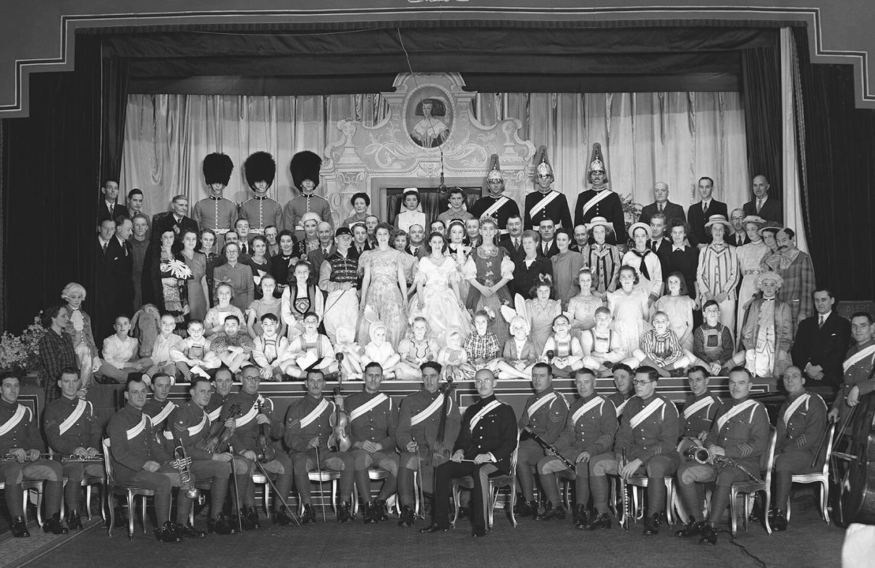 Queen Elizabeth II and Princess Margaret posing with the cast of the Christmas pantomime 'Old mother red riding boots' at Windsor Castle, England on December 23, 1944.