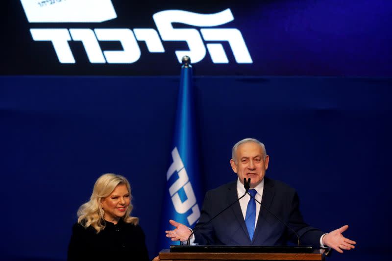 Israeli Prime Minister Benjamin Netanyahu stands next to his wife Sara as he speaks to supporters following the announcement of exit polls in Israel's election at his Likud party headquarters in Tel Aviv