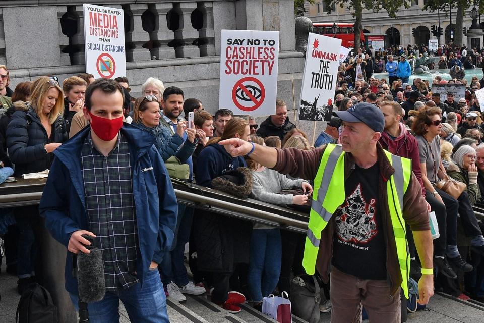 A protester confronts a member of the media who is wearing a mask (AFP via Getty Images)