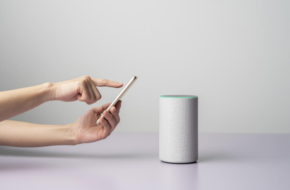 Woman using a Smart speaker with smart phone.