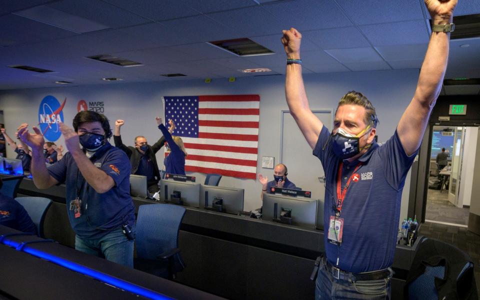 Members of Nasa's Perseverance rover team react in mission control  - Bill Ingalls/NASA