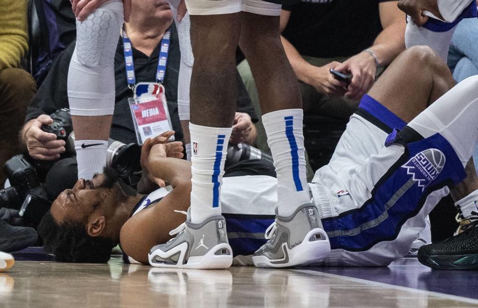 Sacramento Kings guard Malik Monk (0) lies on the court after injuring his knee during an NBA game against the Dallas Mavericks on Friday at Golden 1 Center.