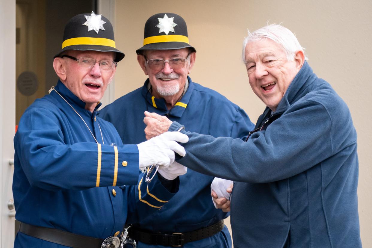 Keystone Cops Terry Losego (left) and Bob Mackley (center) entertain guests as they arrive for the Cambridge Lions Club Music and Comedy Show.