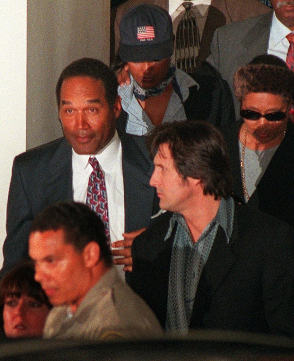 <p>O.J. Simpson, left, leaves Los Angeles County Superior Court in Santa Monica, Calif., after the verdict in the wrongful death civil suit against him Tuesday, Feb. 4, 1997. Simpson was found liable on all counts. (Photo: Michael Caulfield/AP) </p>