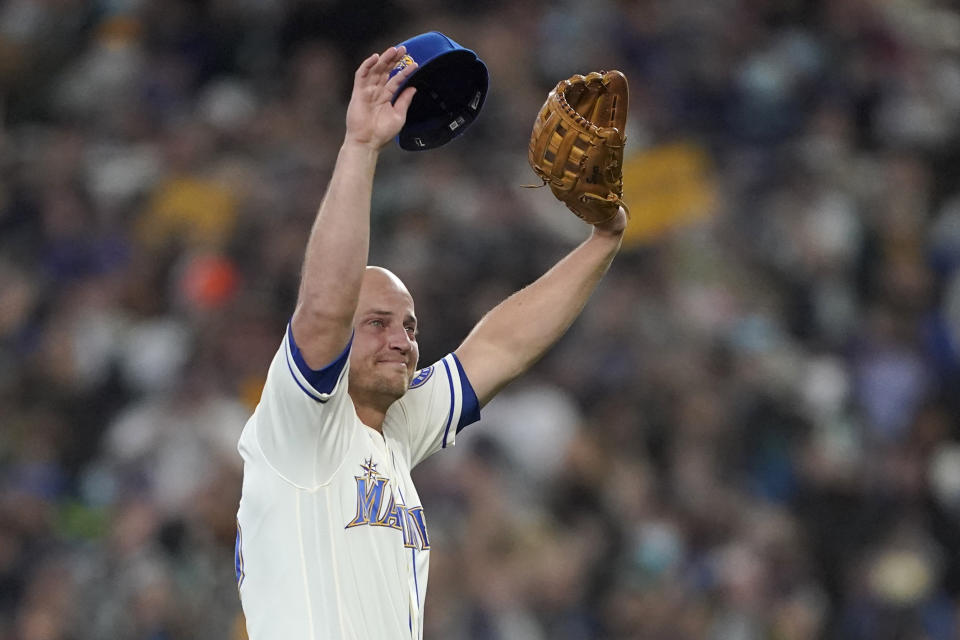 Seattle Mariners third baseman Kyle Seager holds his cap and glove as he responds to the crowd after being subbed out of a baseball game against the Los Angeles Angels during the ninth inning, Sunday, Oct. 3, 2021, in Seattle. (AP Photo/Ted S. Warren)