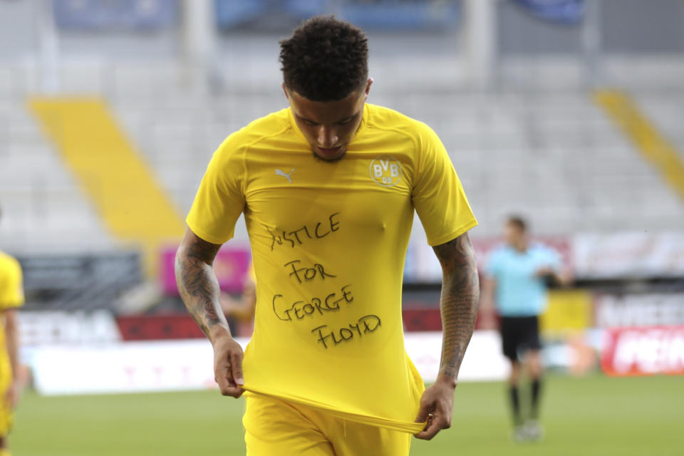 Jadon Sancho of Borussia Dortmund celebrates scoring his teams second goal of the game with a 'Justice for George Floyd' shirt during the German Bundesliga soccer match between SC Paderborn 07 and Borussia Dortmund at Benteler Arena in Paderborn, Germany, Sunday, May 31, 2020. Because of the coronavirus outbreak all soccer matches of the German Bundesliga take place without spectators. (Lars Baron/Pool via AP)