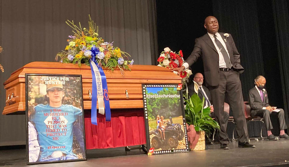 Attorney Ben Crump stands next to Hunter Brittain's casket at the Beebe High School Auditorium before his memorial service in Beebe, Ark. on Tuesday, July 6, 2021. Brittain was shot and killed by a Lonoke County Sheriff's deputy during a traffic stop June 23. (AP Photo/Andrew Demillo)