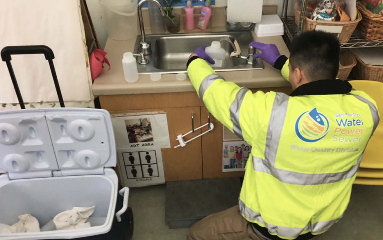 Water quality technician Weldon Ng sample water from a classroom sink in San Francisco in 2018. Prompted by a 2017 state law, schools across California had their water tested for lead to meet a July 2019 deadline.