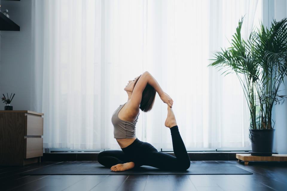 Asian young woman practicing yoga at home