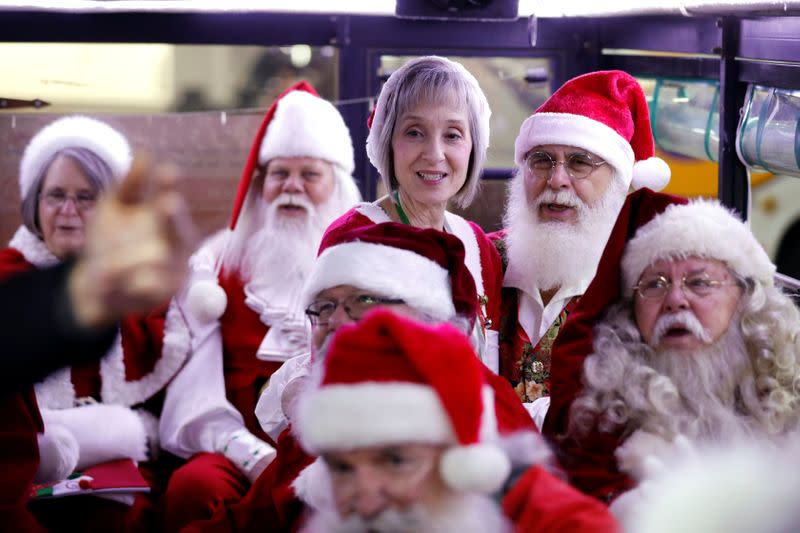 People dressed in Santa Claus outfits sing from inside a bus as they make their way to visit Jerusalem's Old City as a group of Santa Clauses from around the world, in Jerusalem