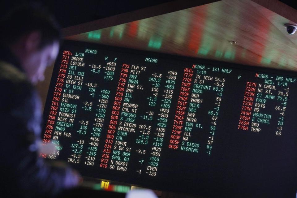 FILE - In this Jan. 14, 2015, file photo, odds are displayed on a screen at a sports book owned and operated by CG Technology in Las Vegas. Las Vegas casinos can't agree on an NCAA tournament favorite, with favorites changing within hours. (AP Photo/John Locher, File)
