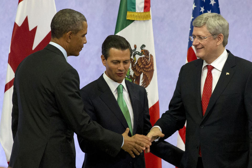 U.S. President Barack Obama, left, Mexican President Enrique Peña Nieto, and Canadian Prime Minister Stephen Harper shake hands at the end of a news conference after the seventh trilateral North American Leaders Summit Meeting in Toluca, Mexico, Wednesday Feb. 19, 2014. This year's theme is “North American Competitiveness.” (AP Photo/Jacquelyn Martin)