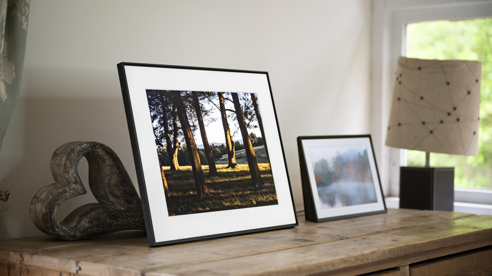 Aura Walden digital photo frame on a wooden sideboard alongside the smaller Aura Carver Mat