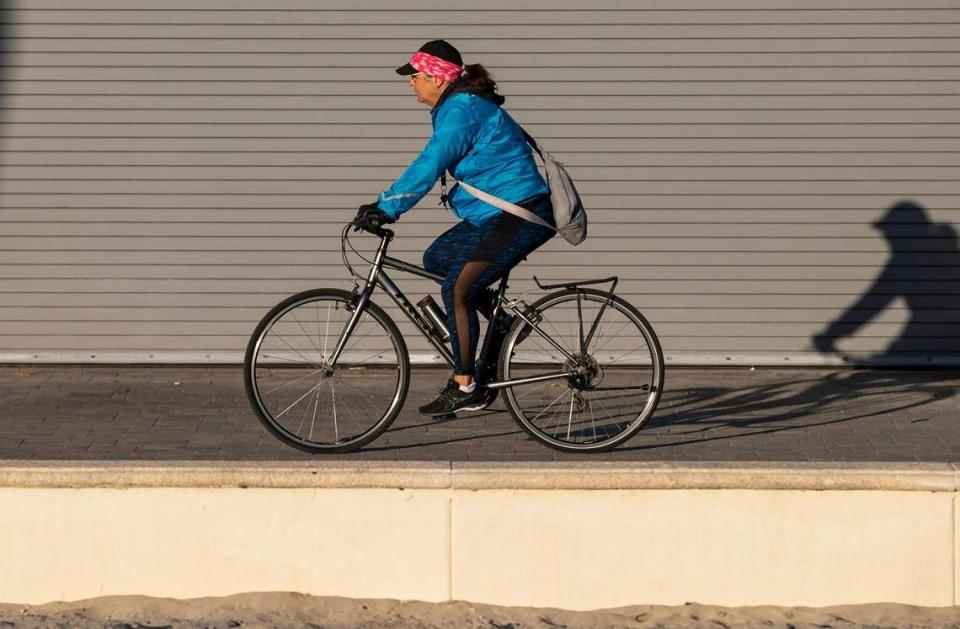 A cyclist makes her way down the Hollywood Beach Broadwalk as temperatures dip into the mid 40s on Saturday, Jan. 14, 2023, in Hollywood, Fla. MATIAS J. OCNER/mocner@miamiherald.com