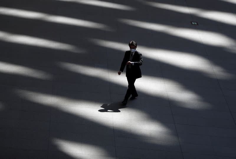 A man wearing a protective face mask, following an outbreak of the coronavirus disease, walks past inside an almost empty convention complex in Tokyo, Japan