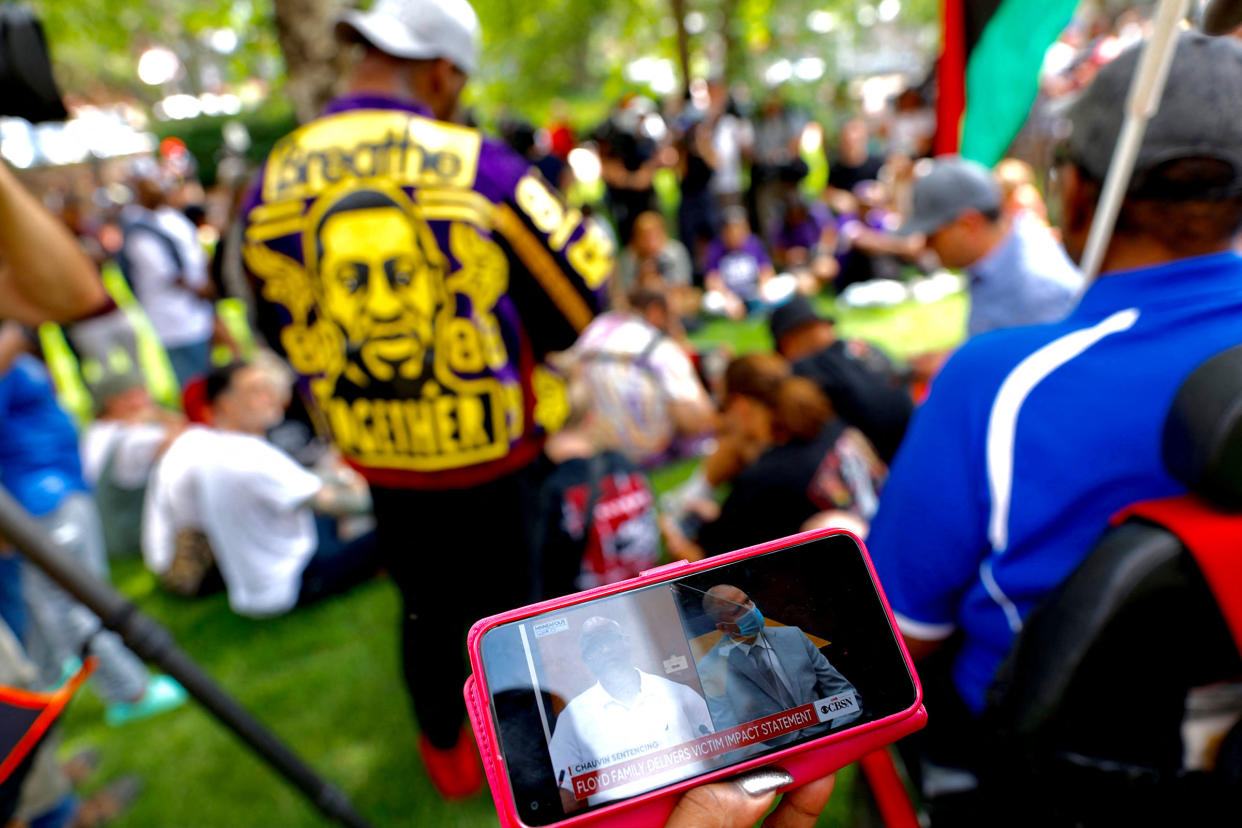 People watch the sentencing hearing of former Minneapolis Police officer Derek Chauvin outside the Hennepin County Government Center in Minneapolis on June 25, 2021.