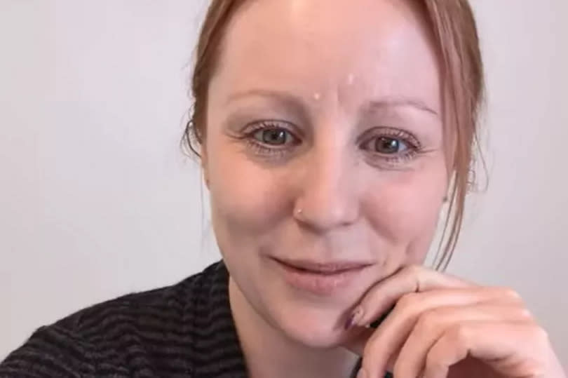 Self-camera shot of Hannah Brown with her hand on her chin in a video still from her YouTube video